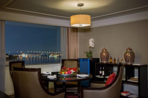 a room with a table and chairs and a window at Ramada Plaza by Wyndham Bangkok Menam Riverside in Bangkok