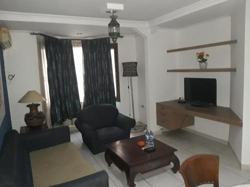 ein Wohnzimmer mit einem Sessel und einem TV in der Unterkunft Maven Buncit in Jakarta