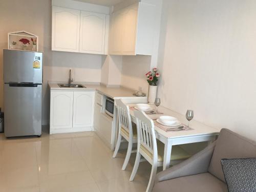 a small kitchen with a table and a refrigerator at The Energy Hua Hin by Jammaree in Cha Am