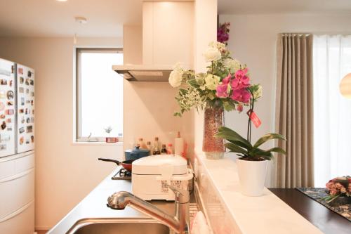 a kitchen with a mixer and flowers on the counter at Uhome Ikebukuro Villa 2 in Tokyo