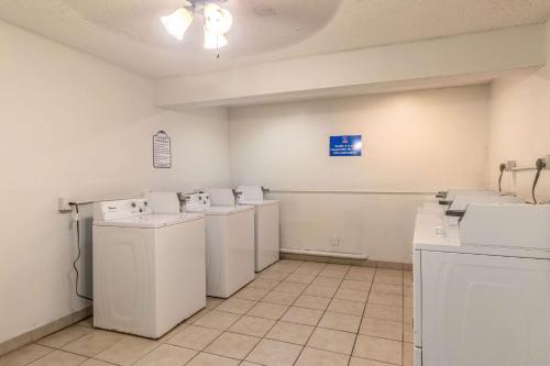 - une buanderie avec lave-linge et sèche-linge blancs dans l'établissement Motel 6-Corpus Christi, TX, à Corpus Christi