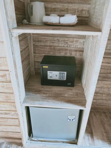 a microwave on a shelf with a box on it at Tiki bar and more in Nusa Lembongan