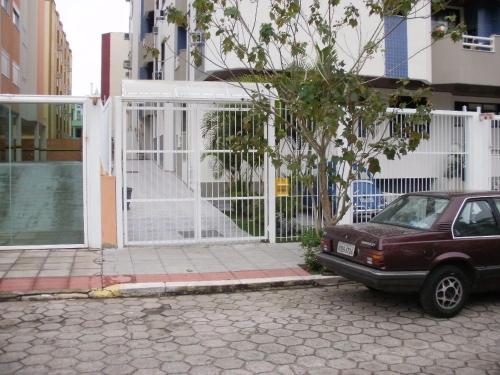 a car parked in front of a white fence at Larus 107 in Florianópolis