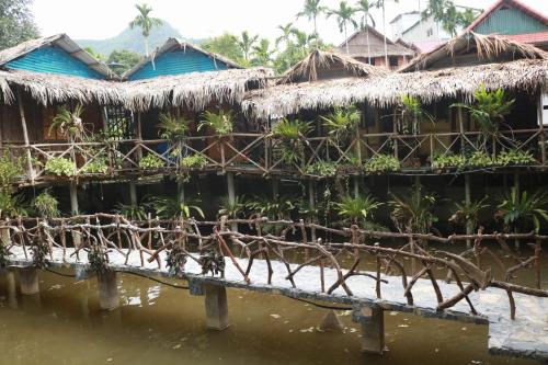 a row of houses with plants in the water at Mai Chau Countryside Homestay in Mai Chau