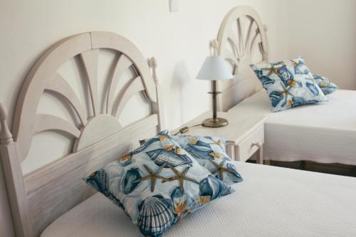 a bedroom with two beds and a pillow on a chair at Dunas do Alvor - Torralvor in Alvor