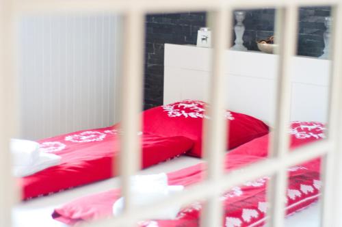 a red bed with red pillows in a room at 2BR apartment close to ski area and Jungfrau train in Grindelwald