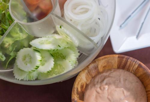 Um prato de comida com alface e uma tigela de molho. em Lanta Miami Resort - SHA Extra Plus em Ko Lanta