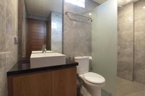 a bathroom with a toilet and a sink and a shower at Matahari Bungalow in Legian