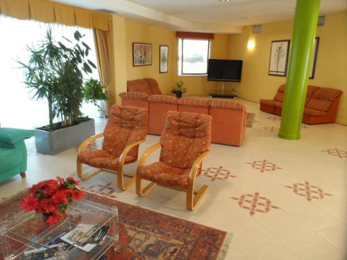 a living room with two chairs and a couch at Hotel Rey Arturo Burgos in Villagonzalo-Pedernales