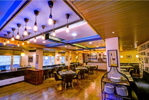 a restaurant with tables and chairs in a room at Udaan Woodberry Hotel & Spa in Gangtok