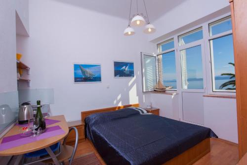 a bedroom with a bed and a table with a desk at Apartments Lara in Podgora