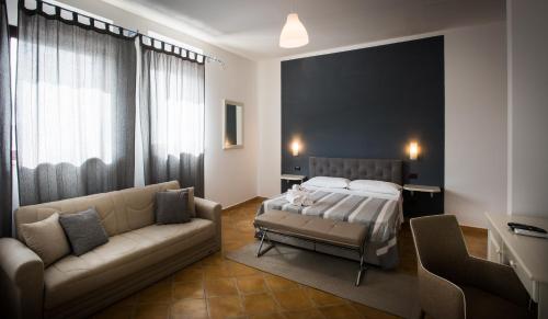1 dormitorio con 1 cama y 1 sofá en Villa Santadi, en Santadi