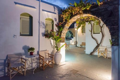 eine Terrasse mit Stühlen und Tischen in einem Gebäude in der Unterkunft Giannakas Studios in Platis Gialos Sifnos