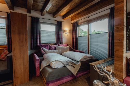 a bedroom with a bed and a couch and windows at Chalet Olivia in Seefeld in Tirol