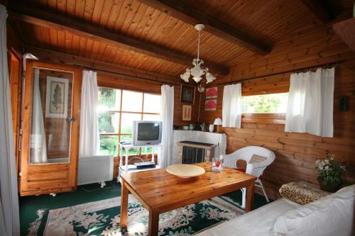 a living room with a table and a fireplace at Haus am Schilift in Sankt Gilgen