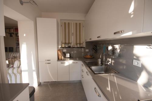 a kitchen with white cabinets and a sink at Castello di Vezio in the Village in Varenna