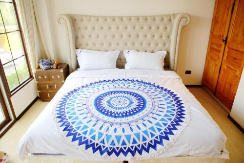 a bedroom with a large blue and white bed at Venetian Poseidon Pool Hotel in Jomtien Beach