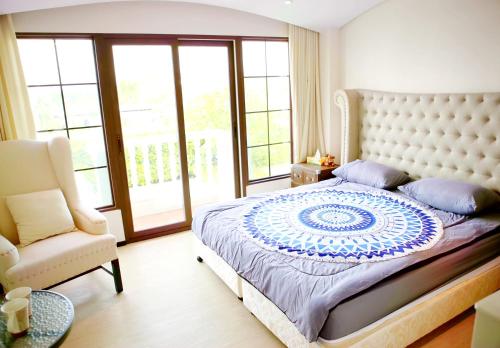 ein Schlafzimmer mit einem großen Bett und einem Stuhl in der Unterkunft Venetian Poseidon Pool Hotel in Jomtien Beach