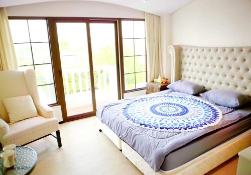 a bedroom with a large bed and a chair at Venetian Poseidon Pool Hotel in Jomtien Beach