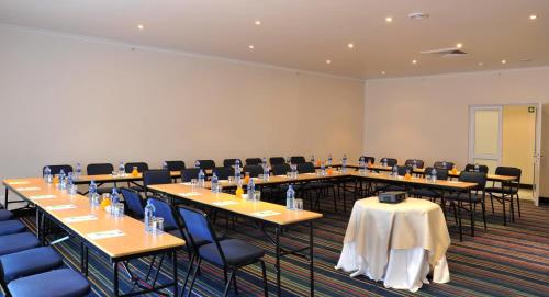 a conference room with long tables and chairs at Premier Splendid Inn Bayshore in Richards Bay