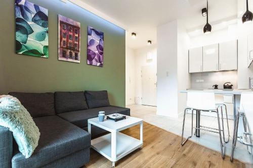 ルブリンにあるPerfect Apartamentのリビングルーム(ソファ、テーブル付)、キッチンが備わります。