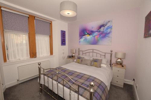 a bedroom with a bed and a painting on the wall at The Stags Head Apartment in Inverness