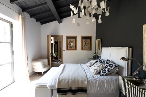 ユゼスにあるMas d orientの白いベッドと黒い壁のベッドルーム1室