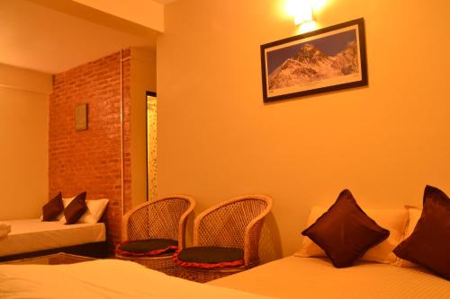 a hotel room with two beds and a chair at Pradhan House - Home Stay with Garden in Bhaktapur