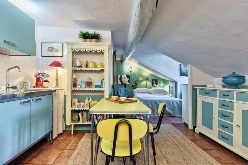 a kitchen with a table and chairs in a room at Mansarda in Piazza Castello in Turin