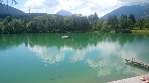 a lake with a dock and a boat on it at Wessely Appartements am Golfplatz in Innsbruck