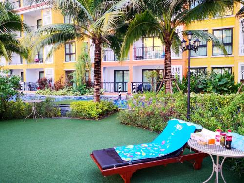 a patio with a chair and a table and a building at Venetian Poseidon Pool Hotel in Jomtien Beach