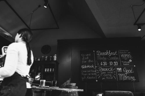 a man walking in a restaurant with a chalkboard at Der LIPPISCHE HOF in Bad Salzuflen