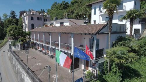 a building with flags on the side of a street at Residence Casa e Vela in Oggebbio
