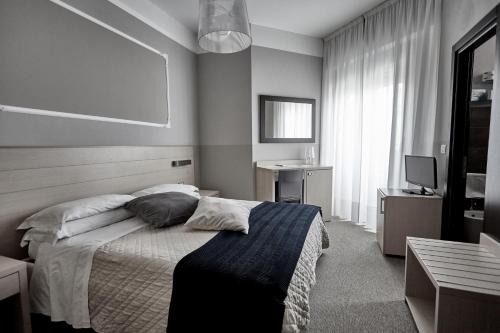 a bedroom with a bed and a television in it at Rouge Hotel International in Milano Marittima