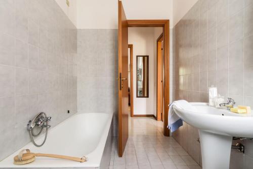 e bagno con vasca, lavandino e vasca. di EXPO CITY - BALZAROTTI BUSINESS APARTMENT by ITALYVING a Rho