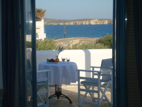 a table and chairs with a view of the ocean at Nissiotiko Studios & Apartments in Drios