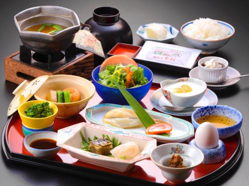 a table with dishes of food on a table at Hotel Kurobe in Kurobe