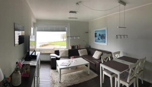 a living room with a couch and a table at Meerblickappartement in Glücksburg