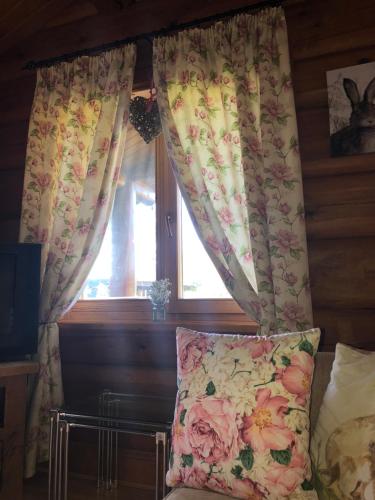 a bedroom with a window with curtains and a pillow at Log home village in Ulverston