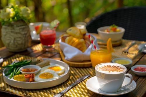 a breakfast table with a plate of eggs and a cup of coffee at Heritage Suites Hotel in Siem Reap