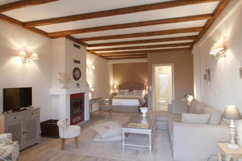 a living room with a couch and a bed and a fireplace at AlmondHouse Suites with Fireplace - ADULTS ONLY in Arachova