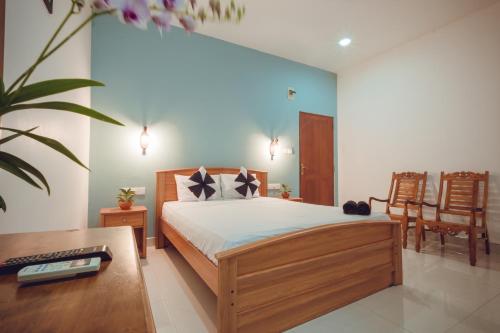 a bedroom with a bed and a desk and chairs at The Cappuccino Hotel in Negombo