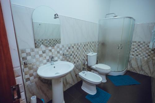 uma casa de banho com 2 WC e um lavatório e espelho em The Cappuccino Hotel em Negombo