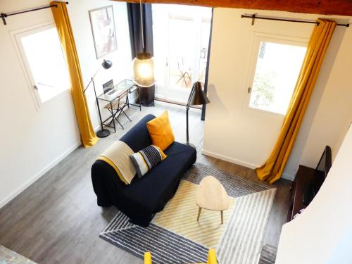 Les Bernardines في آكس أون بروفانس: غرفة معيشة مع أريكة زرقاء ونوافذ