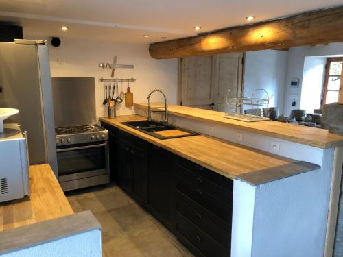 Il comprend une grande cuisine équipée d'un évier et d'une cuisinière. dans l'établissement Gîte L Atelier du Peintre, à Saint-Maurice-de-Lignon