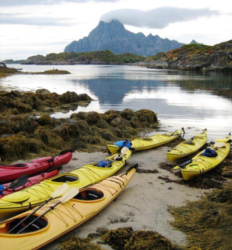 a group of kayaks are lined up on a beach at Thon Hotel Lofoten in Svolvær