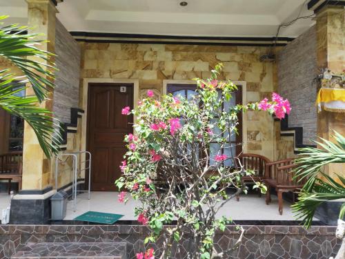 a house with pink flowers on the front porch at Tiki bar and more in Nusa Lembongan