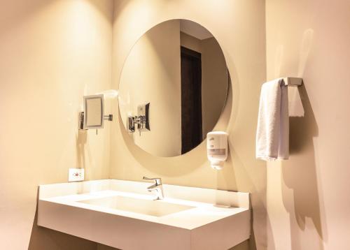 uma casa de banho com um lavatório e um espelho em Hotel F25 em Ibagué