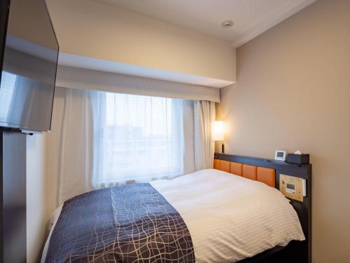 Una habitación de hotel con una cama y una ventana. en APA Hotel Asakusa Ekimae, en Tokio