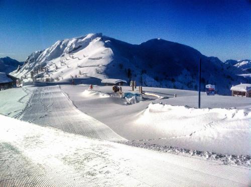 a snow covered ski slope with a mountain in the background at Apartments Bergblick in Sonnenalpe Nassfeld